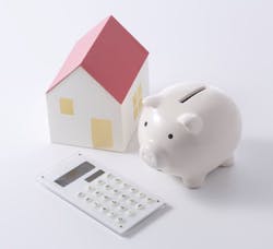 Calculator and piggy bank with a model of a house Calculator and piggy bank with a model of a house