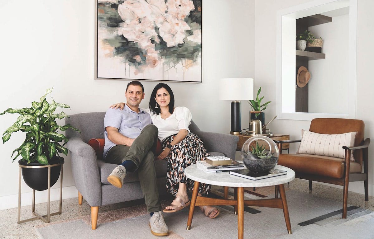 Duoma Atelier's husband and wife team sit on a couch, facing the camera