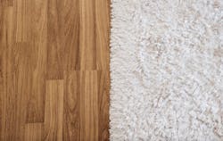 Laminated timber flooring next to white carpet Laminated timber flooring next to white carpet
