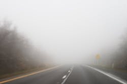 Car driving along a foggy road Car driving along a foggy road