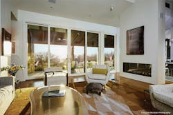 A Sunset Shines Through Glass Sliding Doors Into A Furnished Sitting Room Artwork Is Displayed Above A Nearby Fireplace A Sunset Shines Through Glass Sliding Doors Into A Furnished Sitting Room Artwork Is Displayed Above A Nearby Fireplace