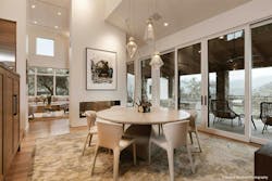 A Tall Dining Space Captures Vast Outdoor Views Through A Wall Of Glass Sliding Doors And Various Large Windows A Tall Dining Space Captures Vast Outdoor Views Through A Wall Of Glass Sliding Doors And Various Large Windows