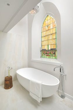 White bath tub and stained glass window White bath tub and stained glass window