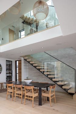 Pushing back the second-floor circulation space and running the central stairwell along the side wall allows light from the courtyard and the rear window wall to flow upward into the core of the house. This also means fewer windows along the side elevations to increase occupants’ privacy. Pushing back the second-floor circulation space and running the central stairwell along the side wall allows light from the courtyard and the rear window wall to flow upward into the core of the house. This also means fewer windows along the side elevations to increase occupants’ privacy.