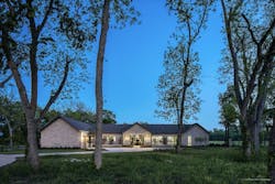Twilight view of Texas custom home stone exterior with breezeway in the middle Twilight view of Texas custom home stone exterior with breezeway in the middle