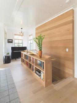 Bookcase doubles as stair railing in piano alcove in net zero house Bookcase doubles as stair railing in piano alcove in net zero house