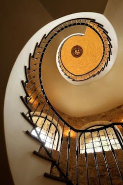 Italian-style stairway design by Richard Landry rising in a stair tower Italian-style stairway design by Richard Landry rising in a stair tower