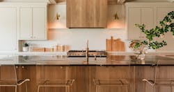 To keep the design cohesive with other spaces in the home, a similar stain was used on both the range hood and kitchen island as the built-in bookcases that can be found in a nearby room. To keep the design cohesive with other spaces in the home, a similar stain was used on both the range hood and kitchen island as the built-in bookcases that can be found in a nearby room.