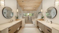 An oversized tub and shower is flanked on either side by two contemporary bathroom vanities. An oversized tub and shower is flanked on either side by two contemporary bathroom vanities.