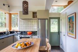 Shown is a contemporary kitchen with a green door and large windows Shown is a contemporary kitchen with a green door and large windows