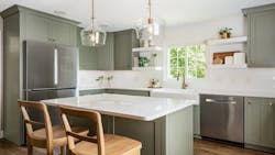 A sage green kitchen with large island in the center A sage green kitchen with large island in the center