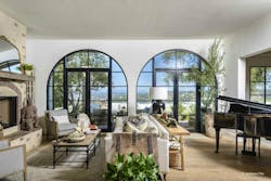 Window grids fill out two arched openings in a modern living space, granting access to the outside with swing doors. Window grids fill out two arched openings in a modern living space, granting access to the outside with swing doors.