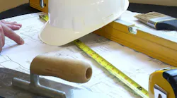 A closeup of a floor plan and tools used for a renovation at a time when home building pros feel cautious about the economy and their business.