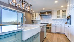 A modern white kitchen with large window letting in natural light A modern white kitchen with large window letting in natural light