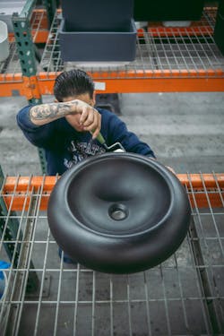 Photo of a factory worker handing sealing one of Concretti Design's sinks Photo of a factory worker handing sealing one of Concretti Design's sinks