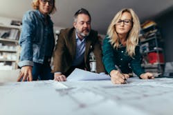 Custom builder leaning over blueprints with clients Custom builder leaning over blueprints with clients