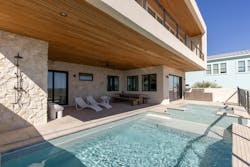 The home's main living space extends outside with a pool and seating area. The home's main living space extends outside with a pool and seating area.