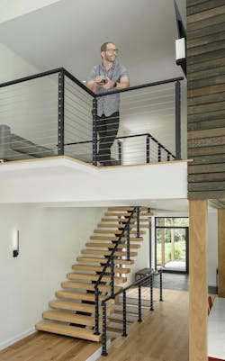 Homeowner overlooking a cantilevered loft in a passive house, overlooking the main living area Homeowner overlooking a cantilevered loft in a passive house, overlooking the main living area