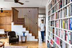 Blurrred image of someone walking into a living room, where a staircase featured sliding louvered doors to create privacy when needed Blurrred image of someone walking into a living room, where a staircase featured sliding louvered doors to create privacy when needed