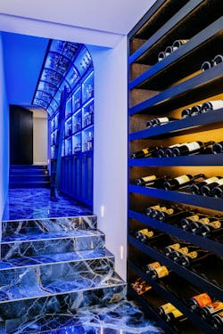 Blue marbelized flooring and colorful LED lighting in the stairwell leading to the underground wine room Blue marbelized flooring and colorful LED lighting in the stairwell leading to the underground wine room