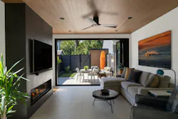 A sliding glass wall to the rear of the home helps connect interior and exterior spaces.