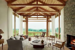 A living room connects to the outdoors through floor-to-ceiling glass. Timber framing and a fireplace add further character. A living room connects to the outdoors through floor-to-ceiling glass. Timber framing and a fireplace add further character.