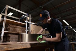 Worker on the Cerno lighting factory, polishing a lamp shade Worker on the Cerno lighting factory, polishing a lamp shade