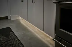 A toe kick area of kitchen cabinetry illuminated with white tape light by Lutron A toe kick area of kitchen cabinetry illuminated with white tape light by Lutron