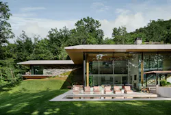 While unassuming from the front, the home opens completely to the back of the property with floor-to-ceiling glass panels. While unassuming from the front, the home opens completely to the back of the property with floor-to-ceiling glass panels.
