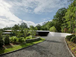 A curved, slanted retaining wall adds a contemporary flair to the home. A curved, slanted retaining wall adds a contemporary flair to the home.