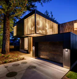 At night, the home's glass walls and cage-like structure light up like a lantern.