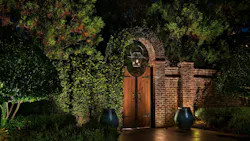 Brick garden gate illuminated at night