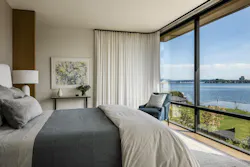 A bedroom with corner glazing over Lake Washington.