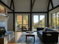 Large windows and bi-fold doors connect the interior and exterior spaces of the barn.