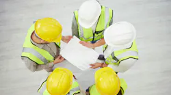 Aerial of construction workers reviewing a plan