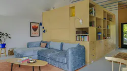 A custom shelving unit in the middle of this ADU optimizes both storage and privacy in a small space.