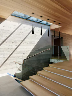 A skylight over the stair lights the board-formed concrete wall